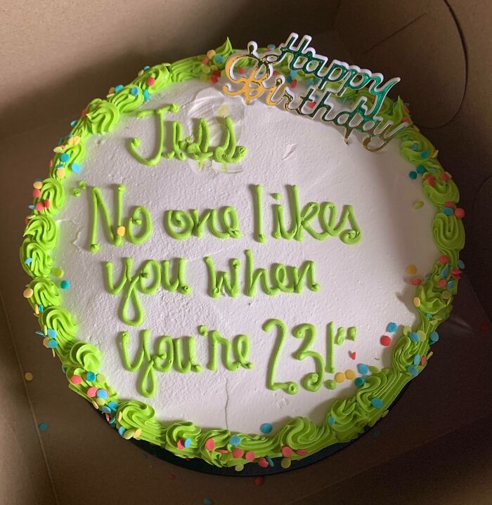 Funny cake with green icing reading no one likes you when you’re 23, reflecting honest emotions in cake photos.