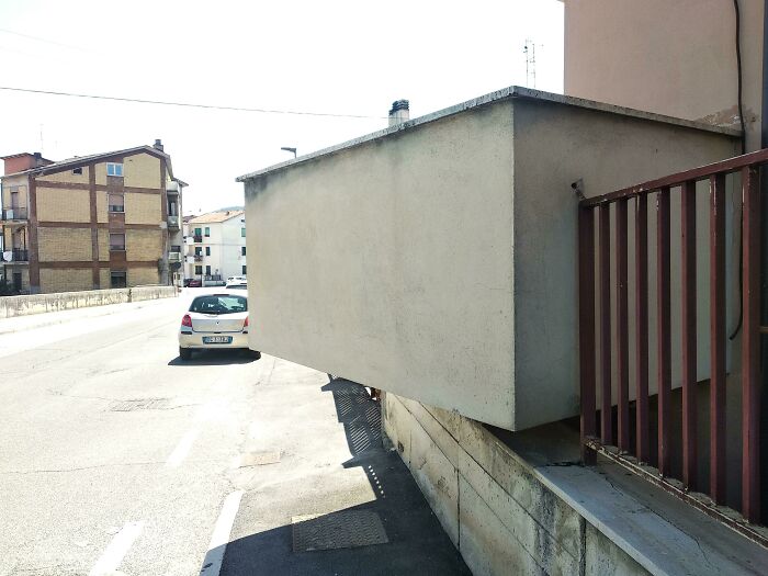 Awkward building extension blocking the sidewalk, an example of terrible product designs that hinder pedestrian movement.