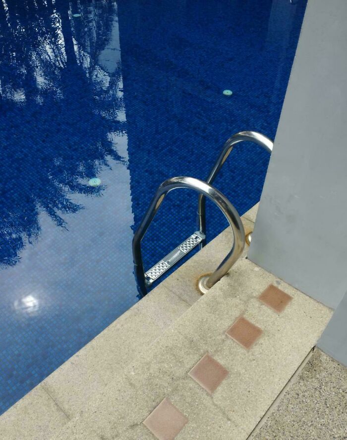 Pool ladder installed with steps submerged underwater, an example of terrible product design that makes no sense.