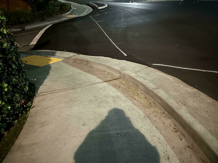 Sidewalk curb ramp missing a proper slope, illustrating a terrible product design flaw in urban accessibility features.