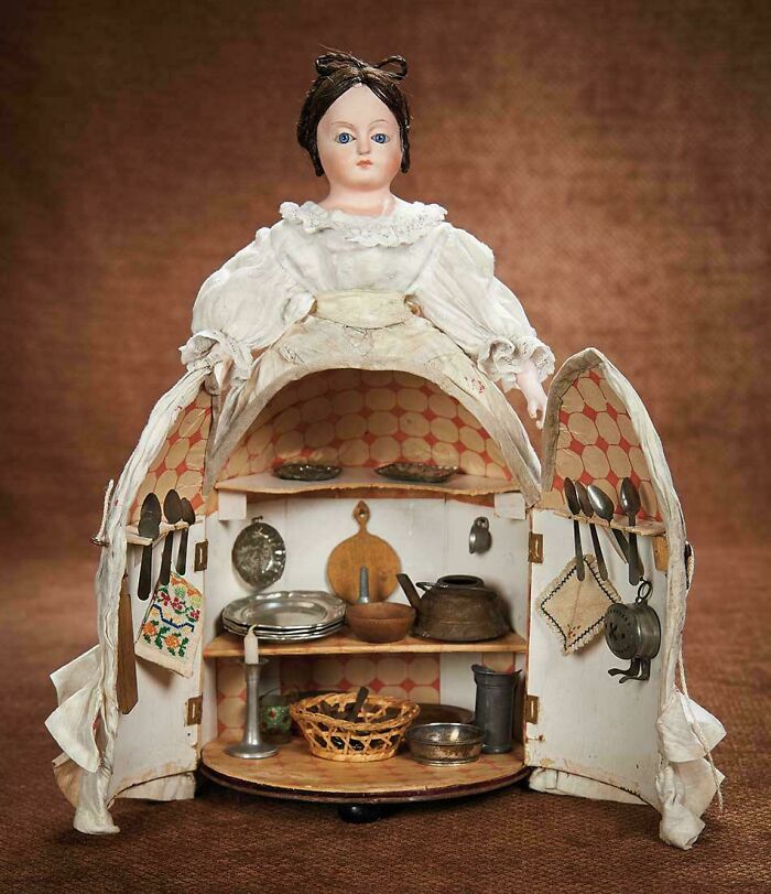 Victorian era doll with hidden miniature kitchen inside dress, showcasing unique vintage household items and design.