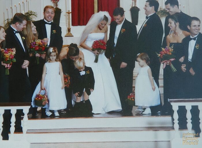 Bride and groom with wedding party caught in an awkward moment on church steps in funny wedding photos.