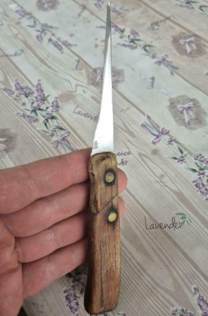 Old wooden-handled knife showing natural wear and tear in everyday objects worn down in unexpected ways.