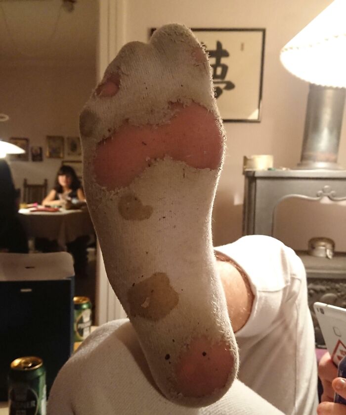 Worn down sock showing holes and frayed fabric, an everyday object worn down in unexpected ways.