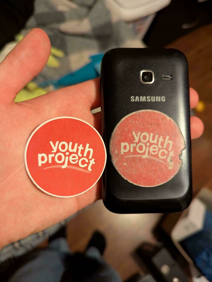 Worn down sticker on the back of a Samsung phone showing effects of everyday object wear in unexpected ways.