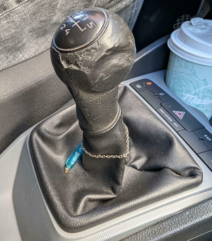 Worn down car gear shift k**b showing cracks and smooth areas from everyday use over time.