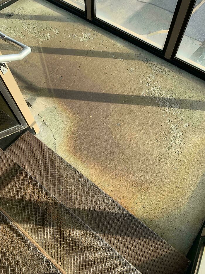 Worn down concrete floor and metal stairs showing natural wear in an everyday object environment.