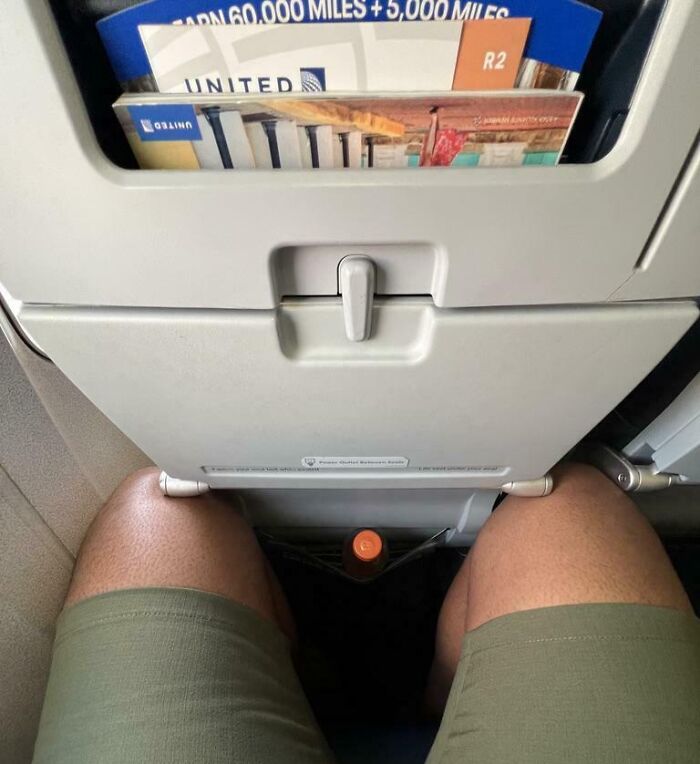 View of cramped airplane seat legroom showing struggles only tall people face during flights with limited space.