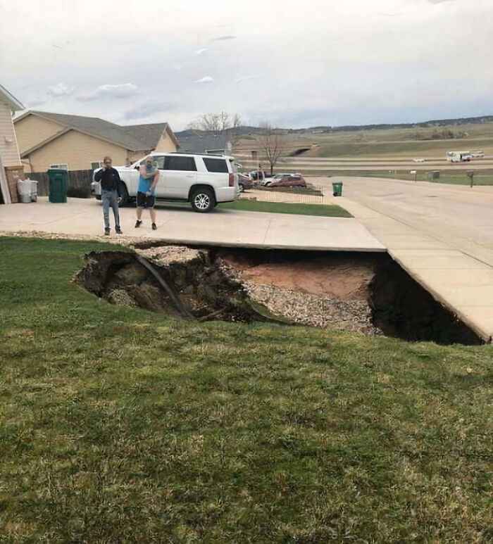 Sidewalk collapse creating a large hole near a house driveway showing an unfortunate and expensive fail.