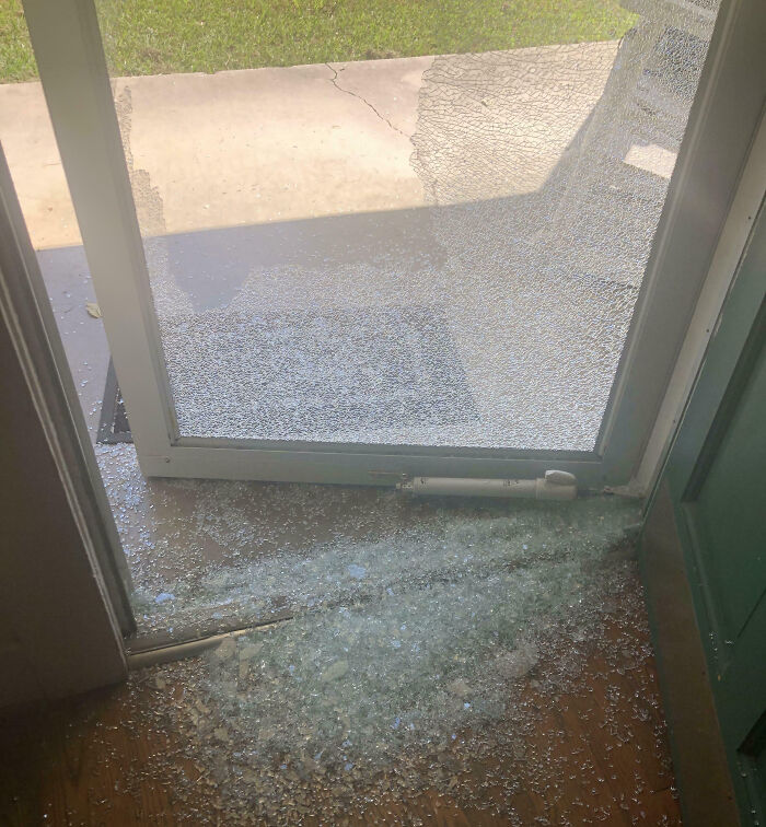 Broken glass door shattered with shards scattered on the floor, illustrating an expensive unfortunate fail.