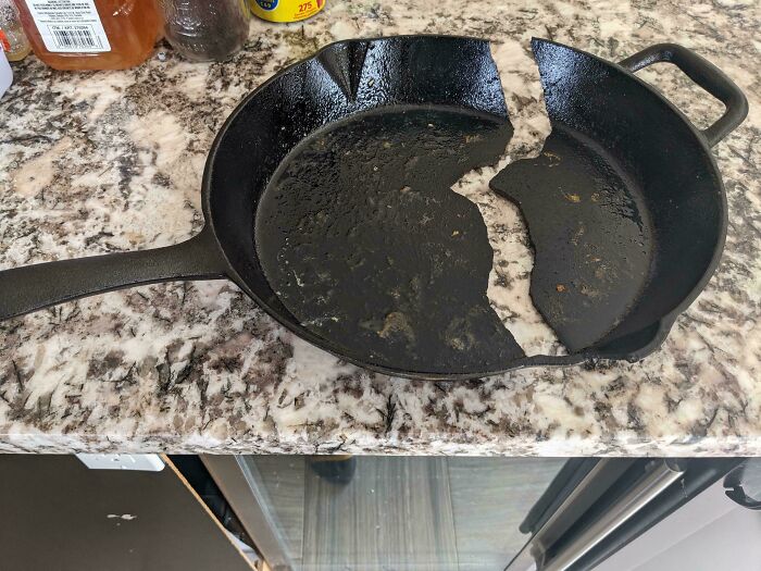 Cast iron skillet broken into large pieces on a kitchen counter, showing an unfortunate and expensive fail.