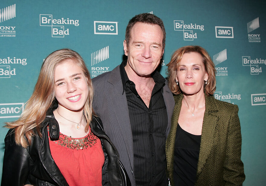 Three people posing together on the Breaking Bad AMC red carpet, highlighting Pitt fans glad one cast member won't bring her famous father.
