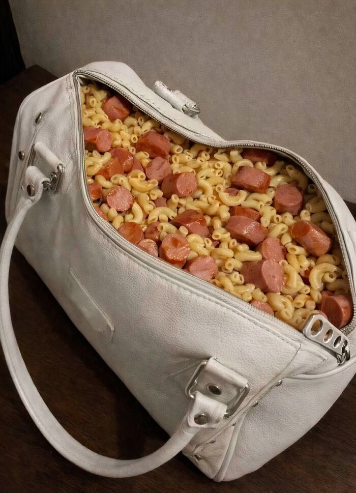 White handbag filled with macaroni and sliced hot dogs, a confusing picture that is funny for no clear reason