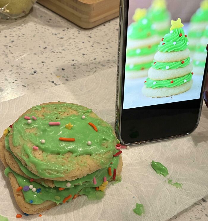 Failed dessert attempt with green frosting and sprinkles that looks nothing like the layered cookie Christmas tree shown on phone screen.