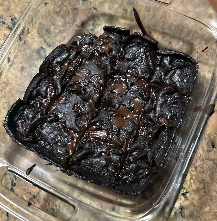 Burnt chocolate dessert in a glass baking dish showing common ways people managed to ruin dessert unexpectedly.