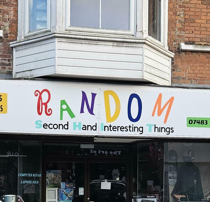 Storefront sign with colorful letters spelling random and words second hand interesting things, a confusing and funny picture.