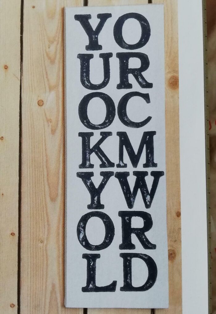 Wooden sign with distorted text spelling a mixed-up message, illustrating designers writing failures and errors.