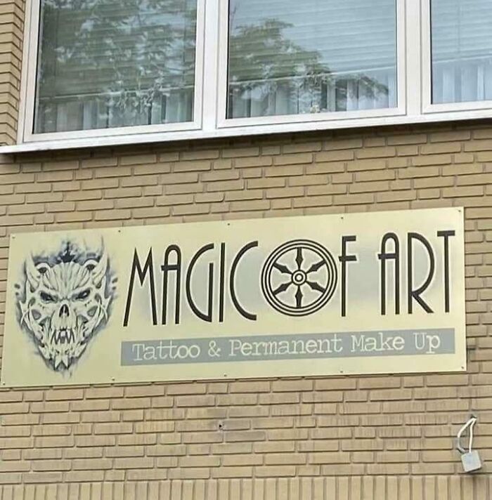 Sign on brick wall for Magic Of Art tattoo and permanent makeup studio with a skull graphic, illustrating design writing fails.