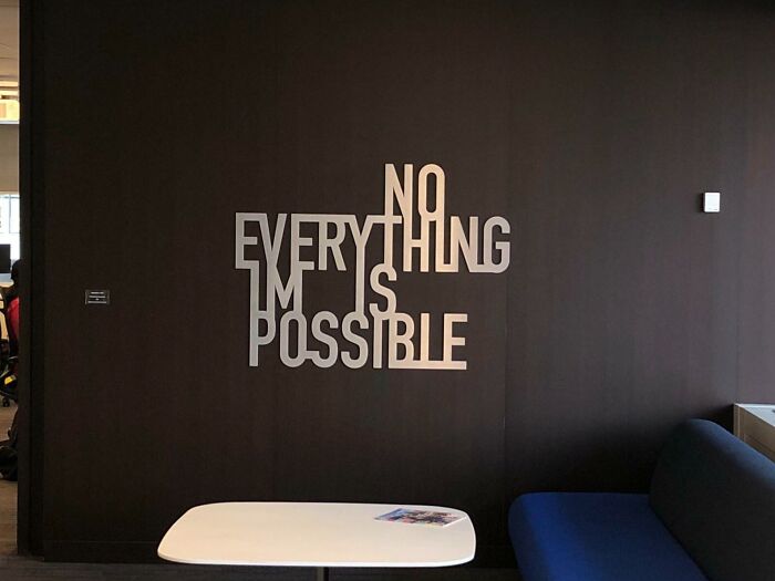 Wall art with a confusing message showing the phrase "NO EVERYTHING IS POSSIBLE" in a modern office space, design fail example