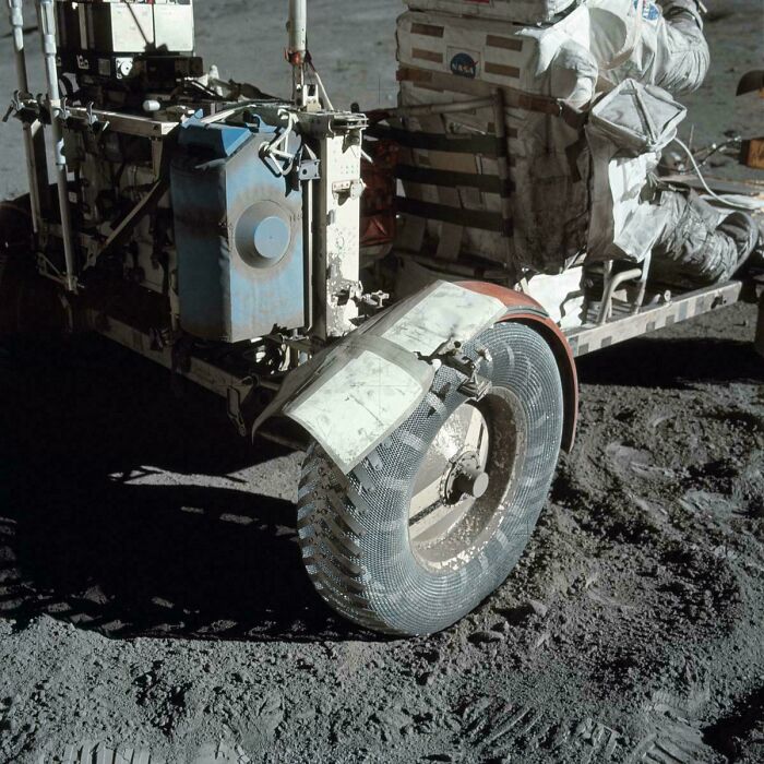 Lunar rover wheel on the moon with an astronaut in a NASA spacesuit during a US history space mission.