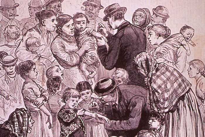 Crowd of families with children receiving medical care in historic US history photo illustrating past life moments.
