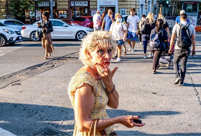 Woman in yellow dress looks surprised on a busy street, capturing candid moments of life in street photos by Perry Hall.