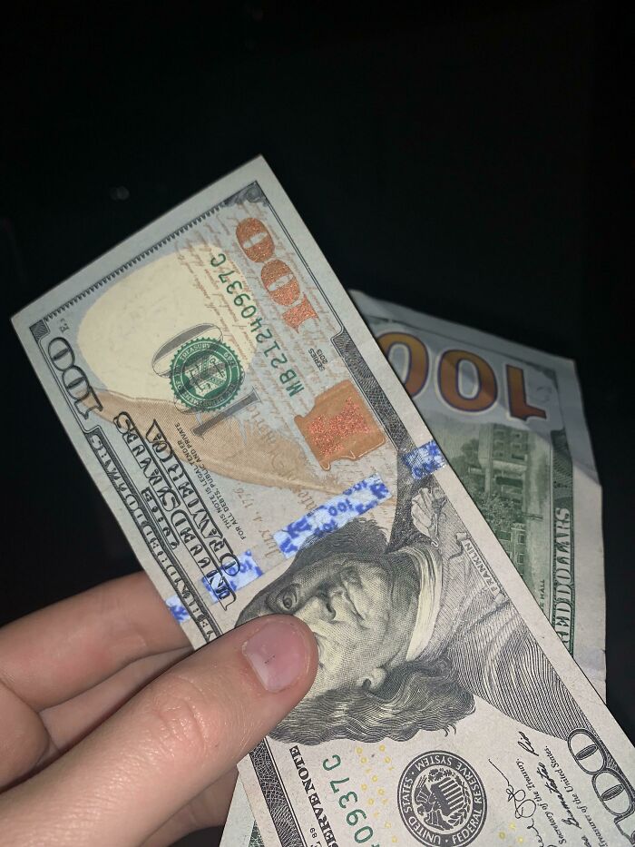 Hand holding a fake 100 dollar bill, illustrating weirdest teacher behavior witnessed in class shared by 48 people.