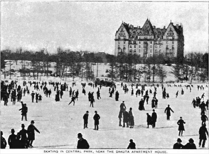 Black and white US history photo of people skating in Central Park near the Dakota Apartment House in winter.