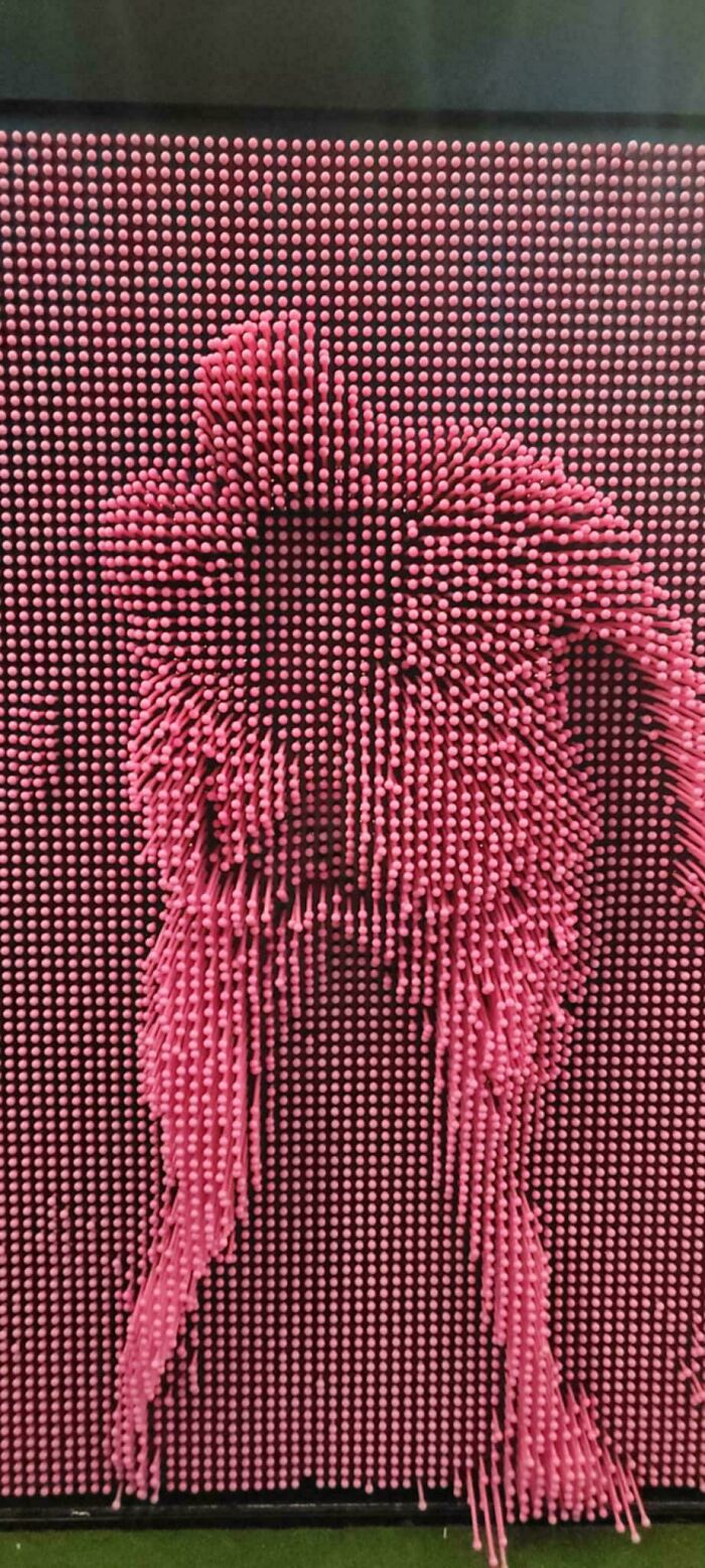 Pink pins wall with an unfortunate event of a missing hand-shaped imprint, illustrating bad timing or accident.