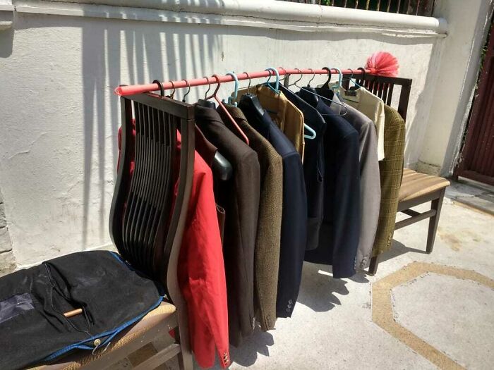 Clothes hanging on a rod supported by two chairs outside, a creative if it works then it's not stupid example.