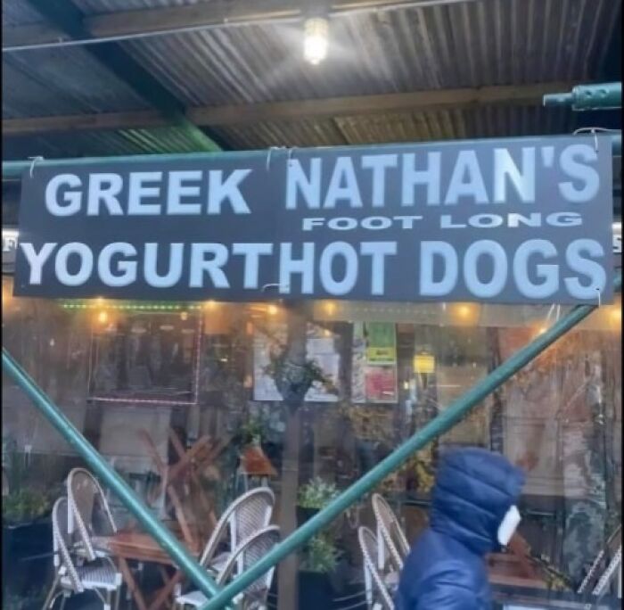 Sign with confusing words Greek Nathan's foot long yogurt hot dogs outside a café, illustrating people breaking their brain trying to understand.