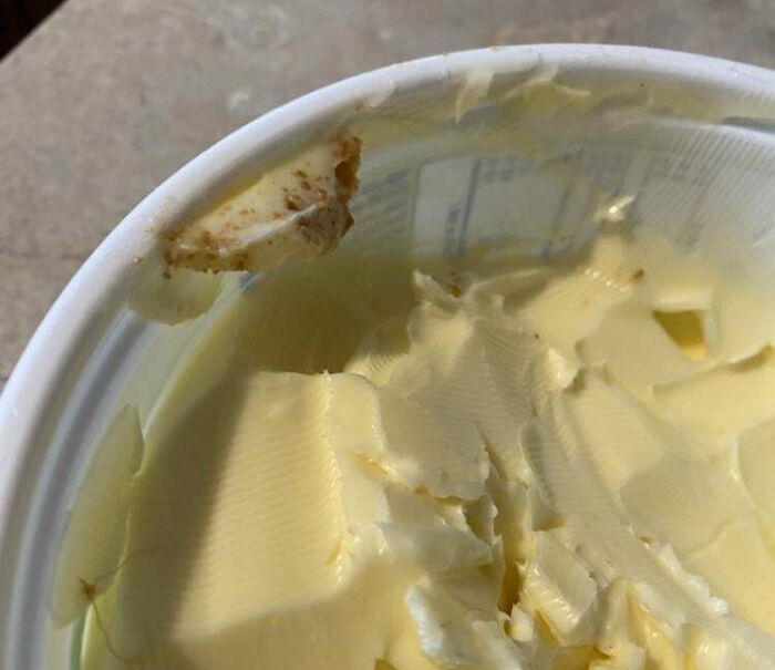 Partially eaten butter with a bite taken from the container edge, illustrating infuriating examples of men being men.