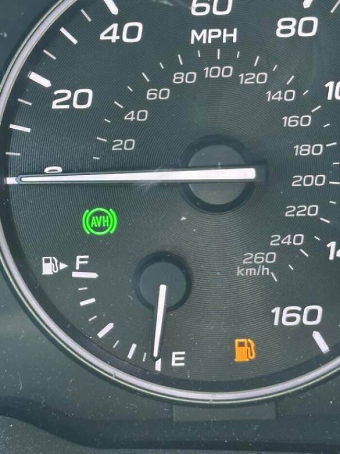 Speedometer close-up showing fuel gauge at empty with low fuel warning, illustrating men being men humor moments.