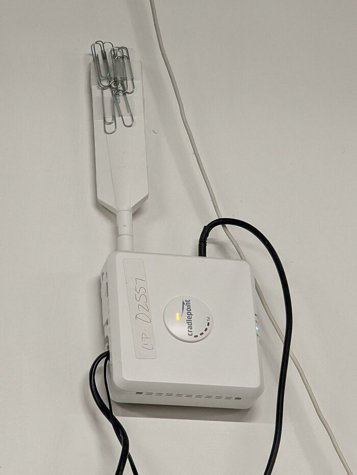WiFi router with a makeshift antenna using paper clips attached to improve signal strength in a creative example.
