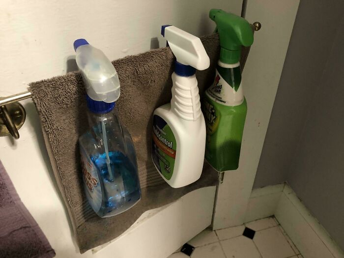 Cleaning spray bottles hanging on a towel, showcasing creative examples of if it's stupid but it works then it's not stupid.