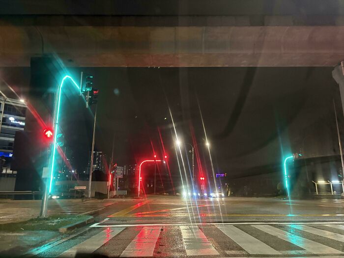 Traffic lights with confusing red and green signals at night under an overpass, showing terrible product designs.