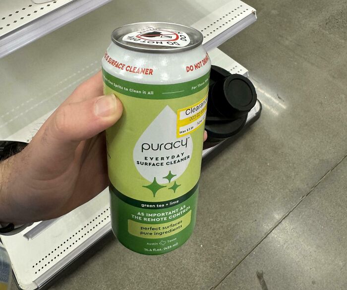 Hand holding a surface cleaner can designed like a soda can, illustrating terrible product designs concept.