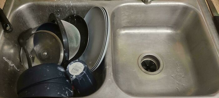 Dirty dishes piled in a kitchen sink showing a typical jerk roommate behavior that makes others want to live alone.