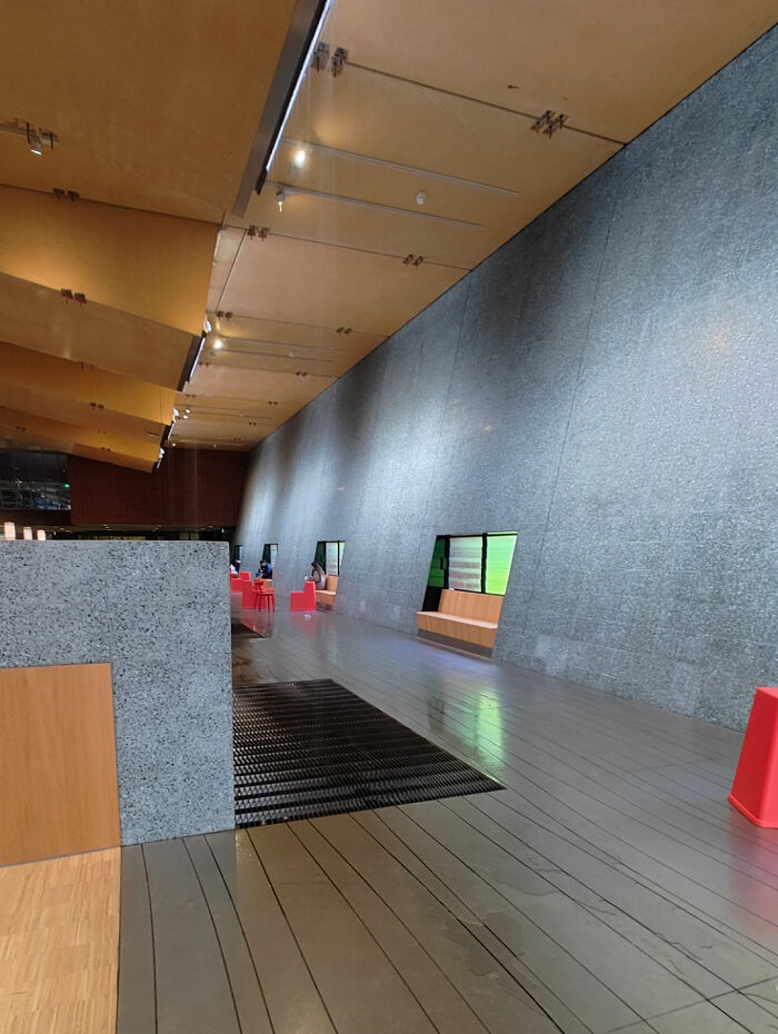 Modern interior with unusual product designs featuring recessed seating and awkward floor grates disrupting the space flow.