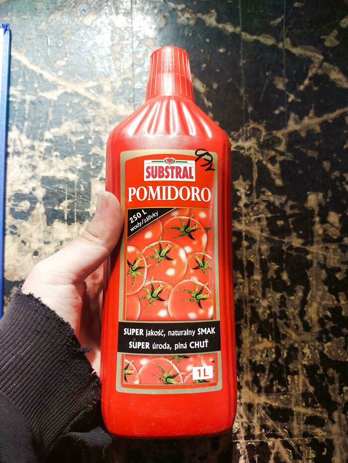 Hand holding a red bottle with tomato images showing terrible product design with confusing packaging.