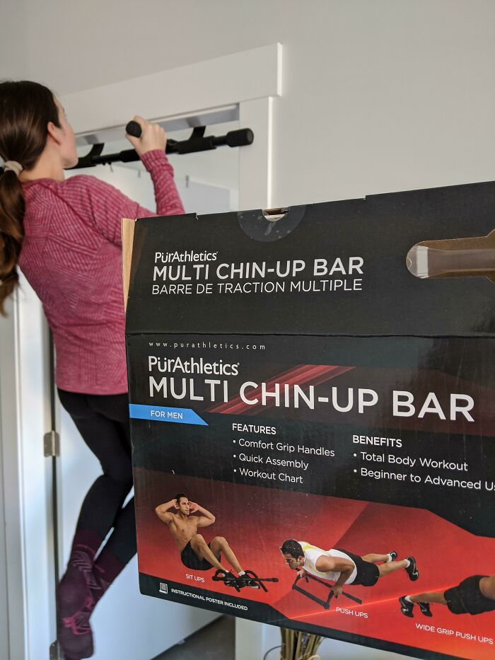 Woman using a multi chin-up bar labeled for men, illustrating gendered nonsense in fitness product marketing.