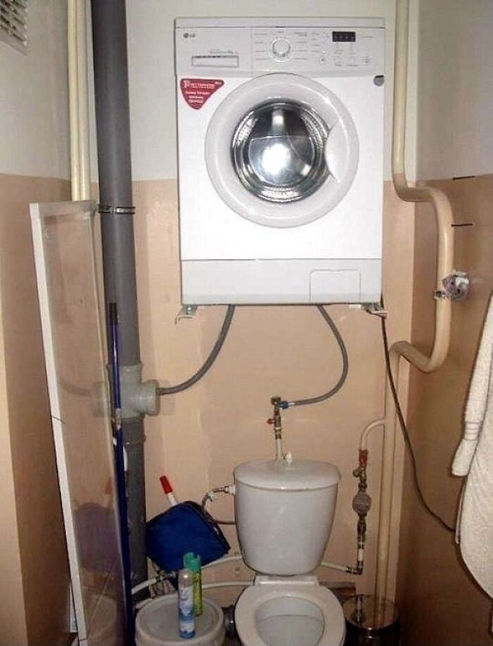 Washing machine awkwardly installed above toilet in a small bathroom, illustrating a major DIY fail and plumbing mistake.