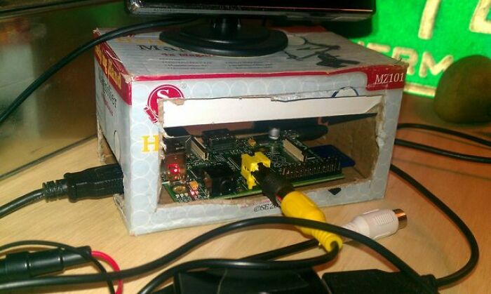 Homemade DIY electronic setup with a circuit board housed inside a cardboard box, showing a failed DIY attempt.