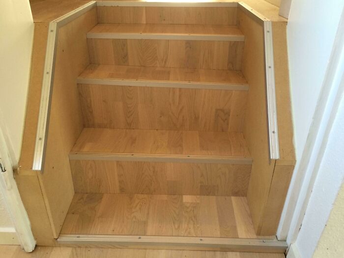 Poorly constructed wooden stairs with uneven edges and visible DIY mistakes in home improvement project failure.