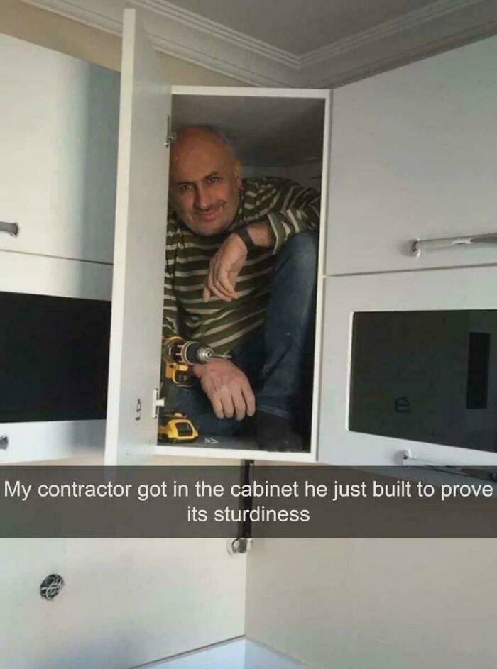 Man crouching inside kitchen cabinet he just built to prove its sturdiness in a funny screenshot moment