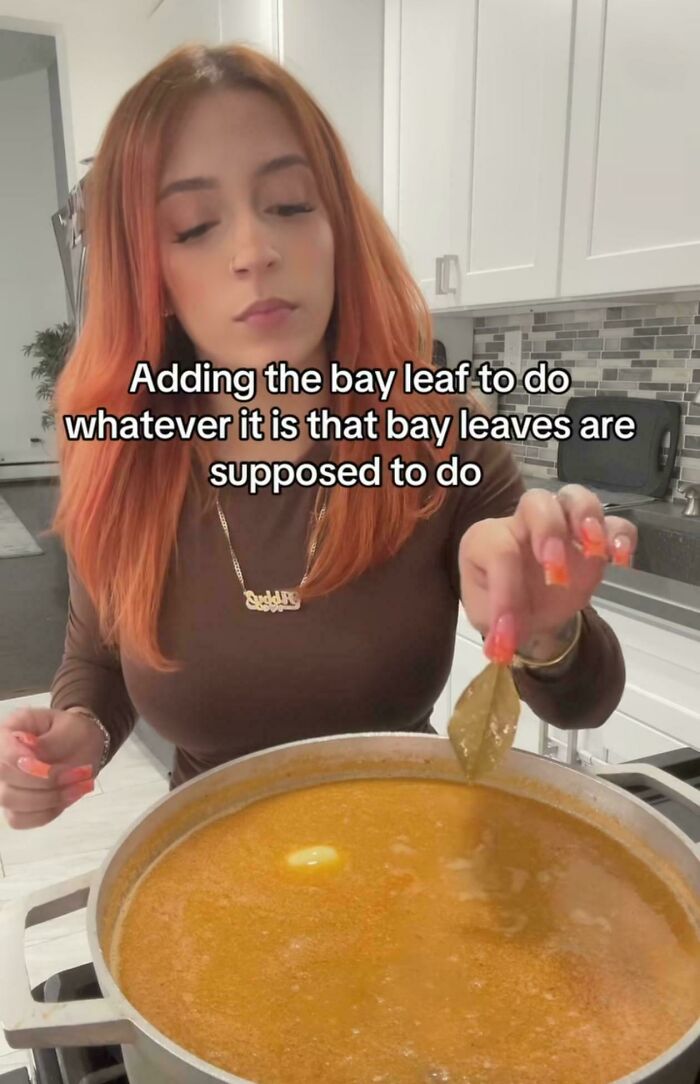 Woman adding a bay leaf to a pot of soup cooking in a kitchen in one of the funniest screenshots people took.