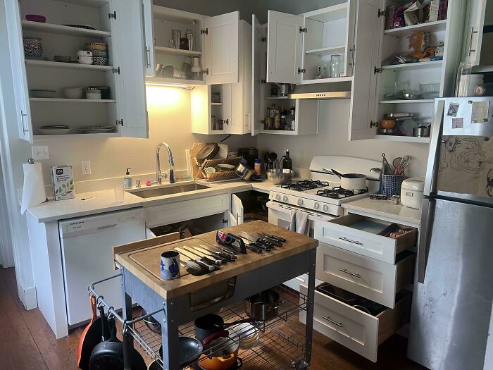 Messy kitchen with open cabinets and drawers, showing clutter that could frustrate roommates living together.
