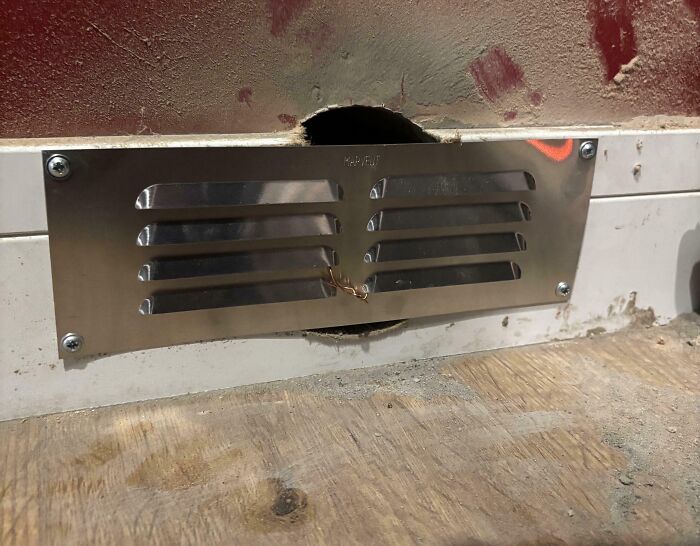 Vent cover improperly installed over a hole in drywall and floor, illustrating a DIY fail requiring correction.