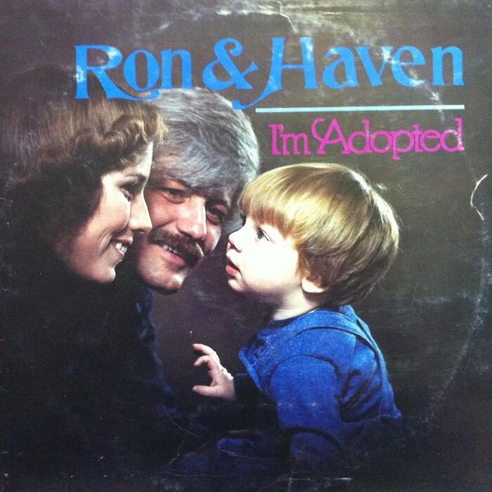 Hilariously bad album cover featuring a family looking at a child wearing blue in a dark setting