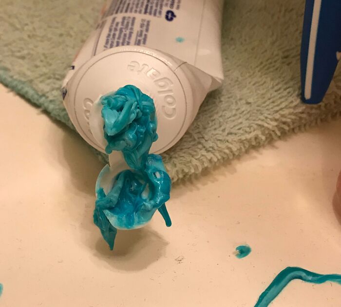 Tube of toothpaste with a messy, dried blue blob squeezed out, illustrating roommate frustrations and jerks living together.